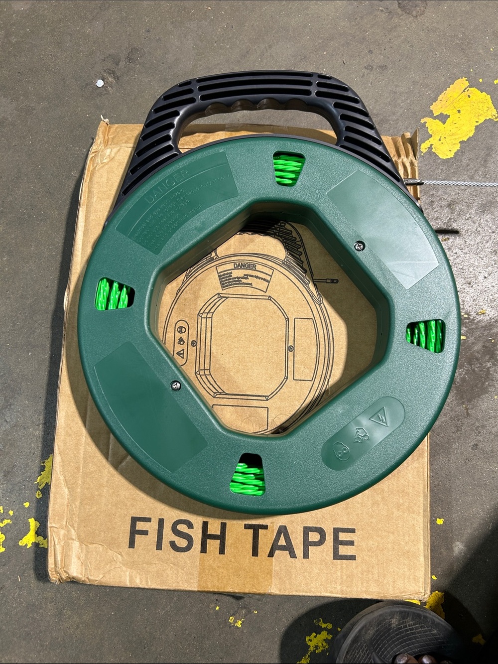 Green Fish Tape Reel with Black Handle. I do not know how long it measures.